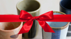 set of four japanese ceramic teacups with a red ribbon tied across the image