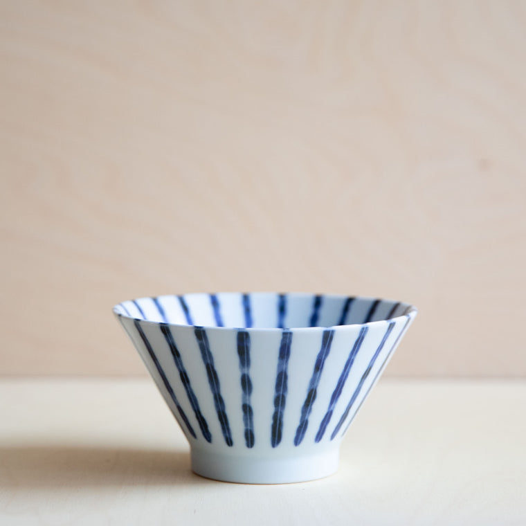 white bowl with blue vertical lines