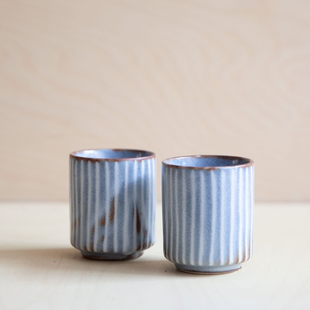 two soft grey teacups with white lines