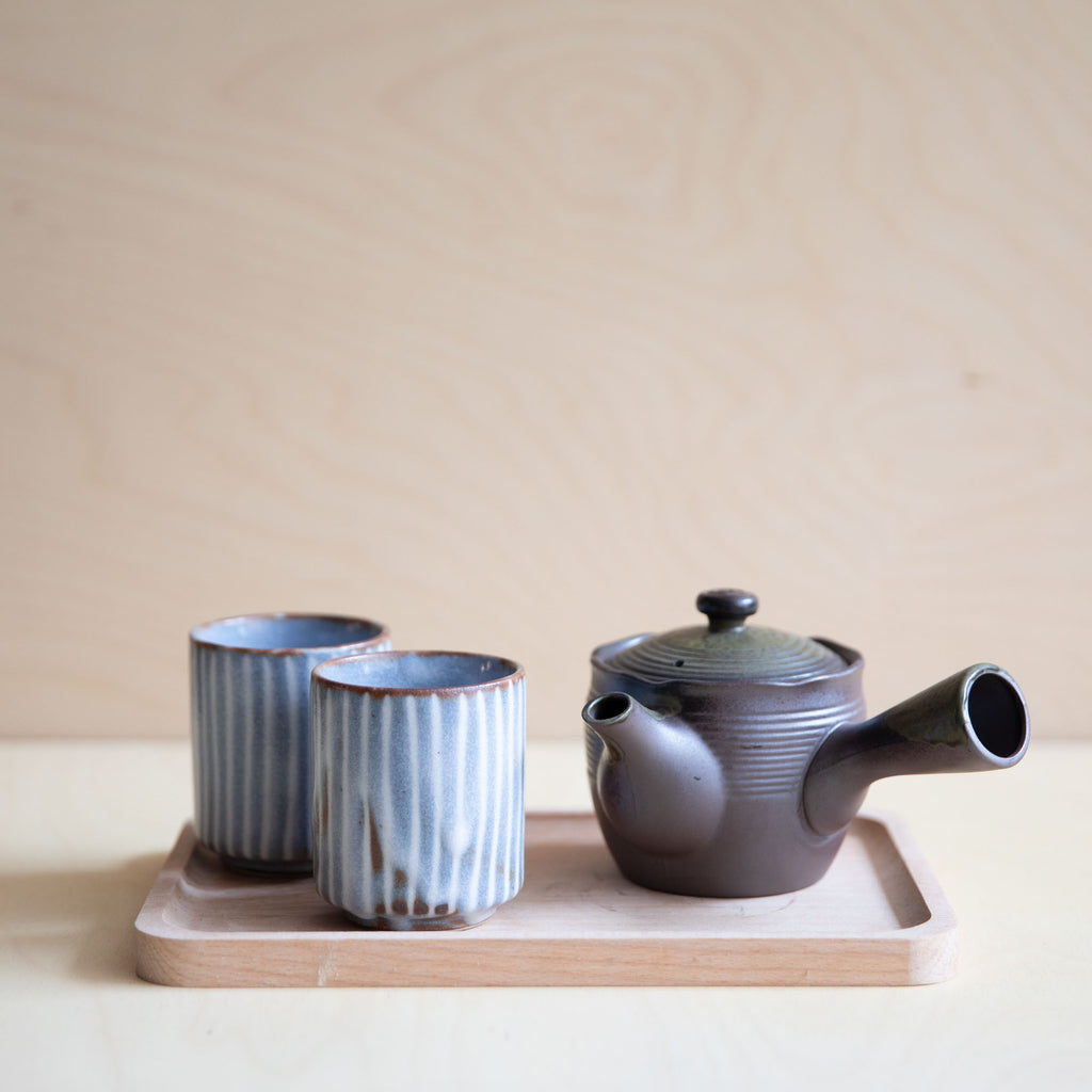 two soft grey teacups with white lines and teapot