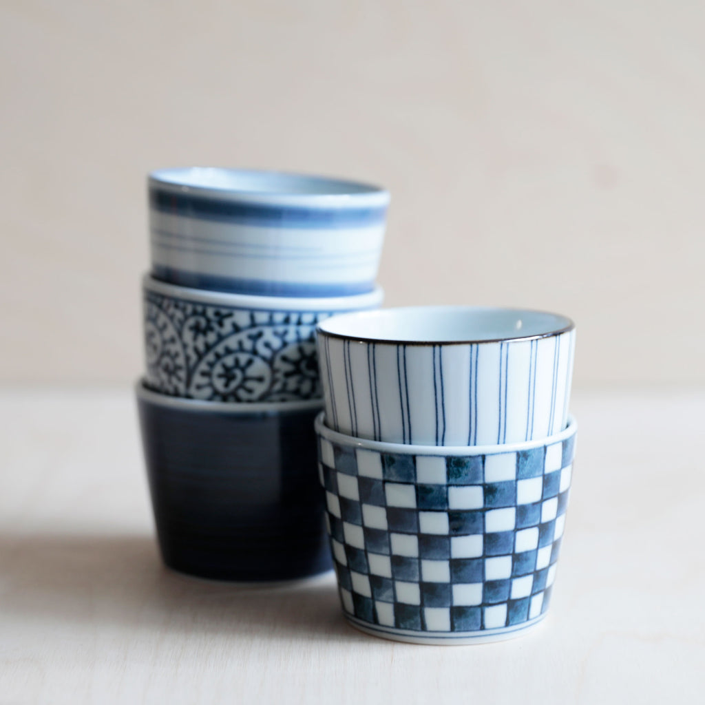 5 Ceramic soba cups in blue and white, stacked on a white background